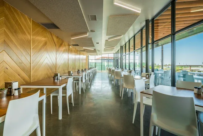 Bright commercial interior with large windows and long shared tables.
