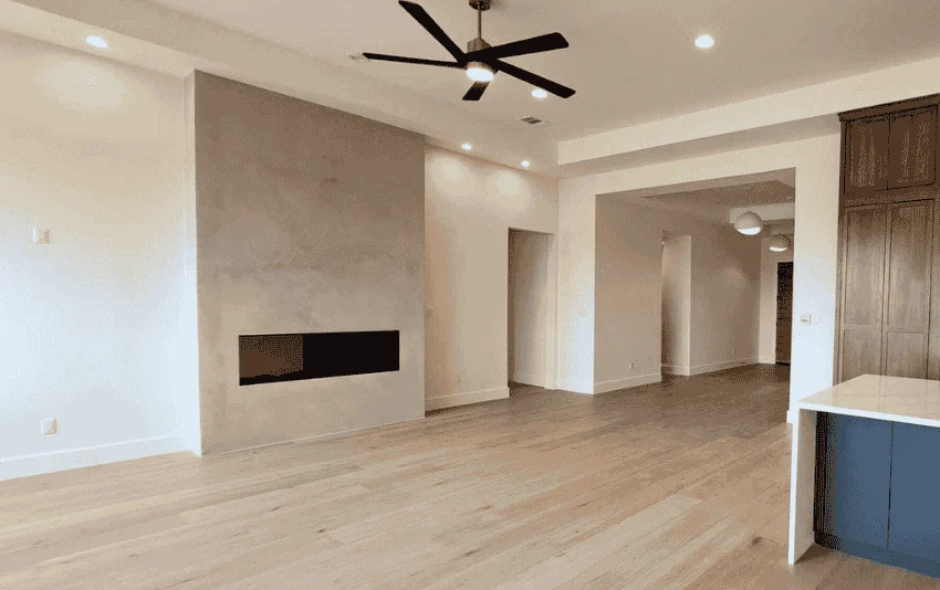 Neutral painted walls and white trim in an open living room with a fireplace.